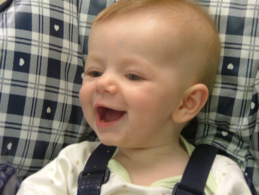 Sam smiles in her high chair